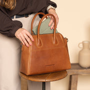 Styled Fit Perspective of Marsala Full-Grain Leather Handbag Damska on Model - Natural Daylight Drape